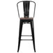 A black metal restaurant bar stool with a wood seat.