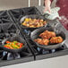 A woman cooking fried chicken in a Choice pre-seasoned cast iron skillet.