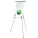 A MasterVision silver metal telescoping tripod display easel holding a white board with a chart on it.