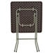 The back of a Flash Furniture brown plastic rattan folding table.