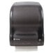 A black San Jamar Simplicity Essence paper towel dispenser with a black roll of paper towels inside.