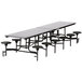 A long rectangular black table with black stools on it.