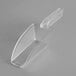 A clear plastic scoop with a handle in a clear plastic wall mount holder.