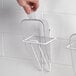 A hand holding a clear plastic utility scoop.