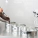 A woman pouring chocolate into a Winco springform cake pan.