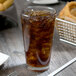 An Anchor Hocking Swirl cooler glass of iced tea on a table.