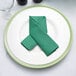 a green napkin folded on a white plate