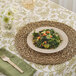 A Bambu Veneerware bamboo plate with salad and a wooden fork on a table.