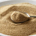 A spoon with brown sand in a bowl.