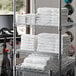 A rack of Lavex Economy white bath towels.
