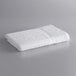 A white Lavex Economy bath towel on a gray surface.
