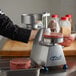 A person using an Edlund hamburger patty press to make hamburger patties.