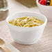 A bowl of noodles with soup in a Dart insulated foam container.