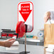 A person using the Turn-O-Matic manual ticket dispenser on a countertop.