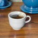 A Fiesta white china cup filled with tea on a table.