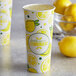 a cup of lemonade with a bowl of lemons