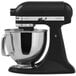 A black KitchenAid Artisan countertop mixer with a silver bowl.