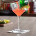 A bartender pouring a cocktail into a Libbey Reserve Prism Coupe Glass.