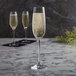 Three Spiegelau Salute champagne flutes on a marble table.