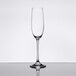 A clear Spiegelau flute wine glass on a reflective surface.