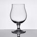 A close-up of a clear Libbey Belgian beer glass with a reflection.