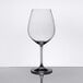 A close-up of a Spiegelau Salute burgundy wine glass on a reflective surface.