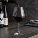 A Spiegelau Burgundy wine glass being filled with red wine.