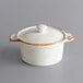 An Acopa Keystone vanilla bean stoneware mini casserole dish with a white lid.