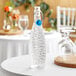 A Libbey glass bottle with a blue wire bail lid on a table.