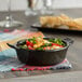 A bowl of corn salad in an Acopa Keystone mini casserole dish with handles on a table.