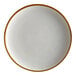 An Acopa Keystone vanilla bean stoneware coupe plate with brown specks.