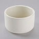 A white Tuxton eggshell china soup cup on a gray surface.