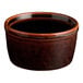 A small, round, brown stoneware ramekin with a glossy finish.