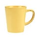 A Libbey butter yellow porcelain mug with a black handle.