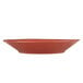 A Libbey round barn red porcelain bowl with a small design on it.