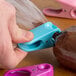 A hand using a Fox Run plastic clip to close a pastry decorating bag.