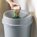 A hand holding a coffee cup in a Rubbermaid Untouchable trash can with a funnel lid.