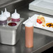 a metal container with condiments and a plate of desserts