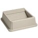 A beige square Rubbermaid Untouchable drop shot lid with a hole.