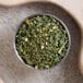 A bowl of chopped Regal chives on a wooden cutting board.