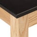 A black National Public Seating science lab table with wood grain.