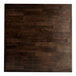A Lancaster Table & Seating square wooden bar height table with espresso finish and cast iron base.