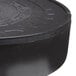 A close up of a black Carlisle plastic circular tortilla server with a circular pattern.