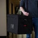 a person holding a black bag