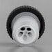 A black plastic wheel with two holes on it.
