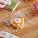 A hand holding a LK Packaging plastic bag of pie-shaped cookies with a thank you label.