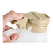 A close-up of a hand holding a plastic dispenser with a beige flip-top lid.
