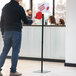 A man using a Garvey black display stand with a red sign.