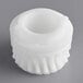A white plastic gear with a hole in it.