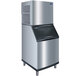 A large stainless steel Manitowoc air cooled flake ice machine with a black top.